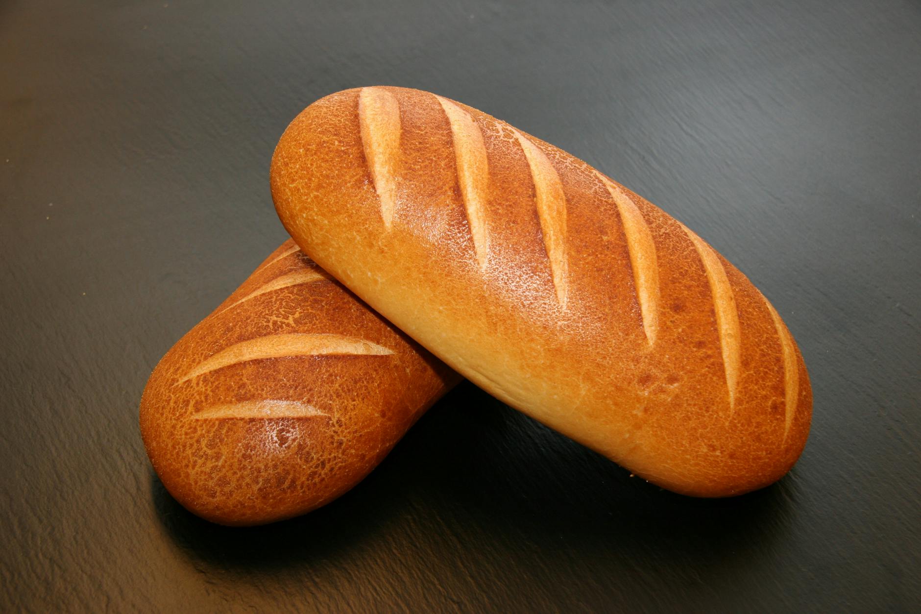 two brown baked breads on table