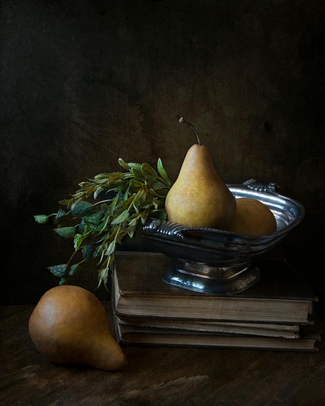 peaches on footed bowl over book