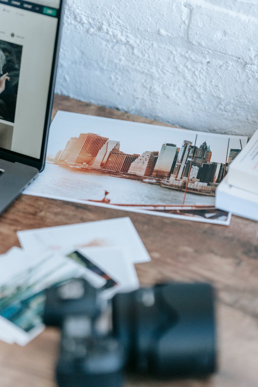 images scattered on desk near laptop