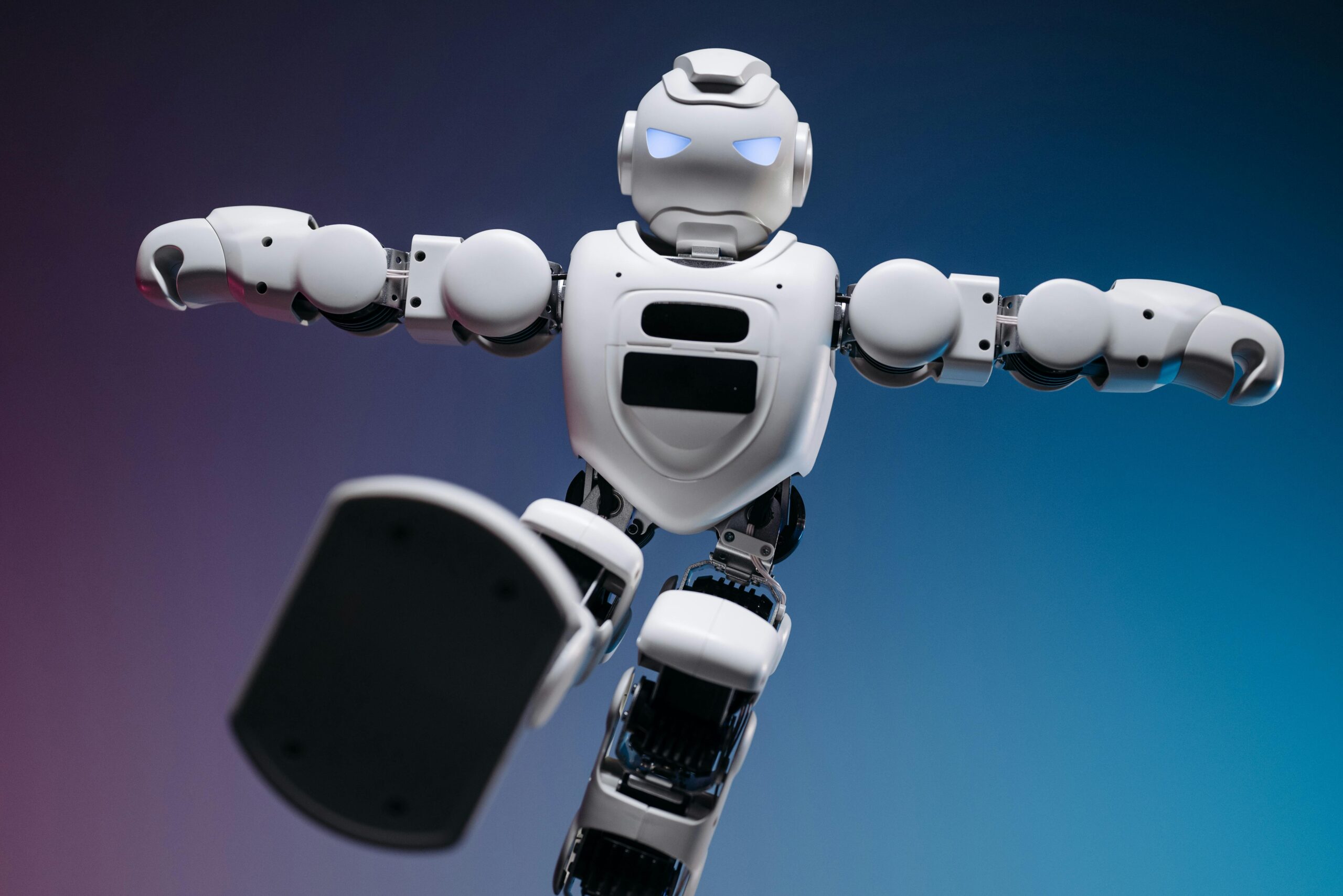 Close up shot of white toy robot on blue and pink background